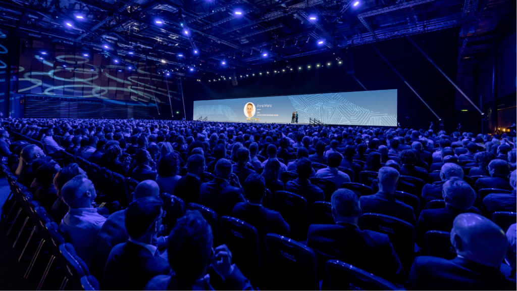 Oracle Cloud World Tour event main stage with large LED screen and keynote speaker and audience watching